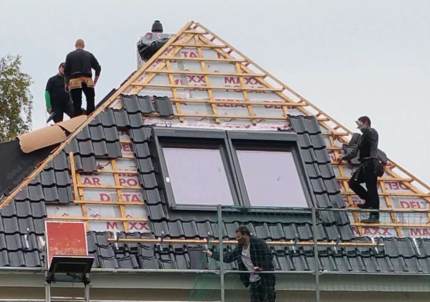 Handwerker bei der Bearbeitung eines Dachaufbaus